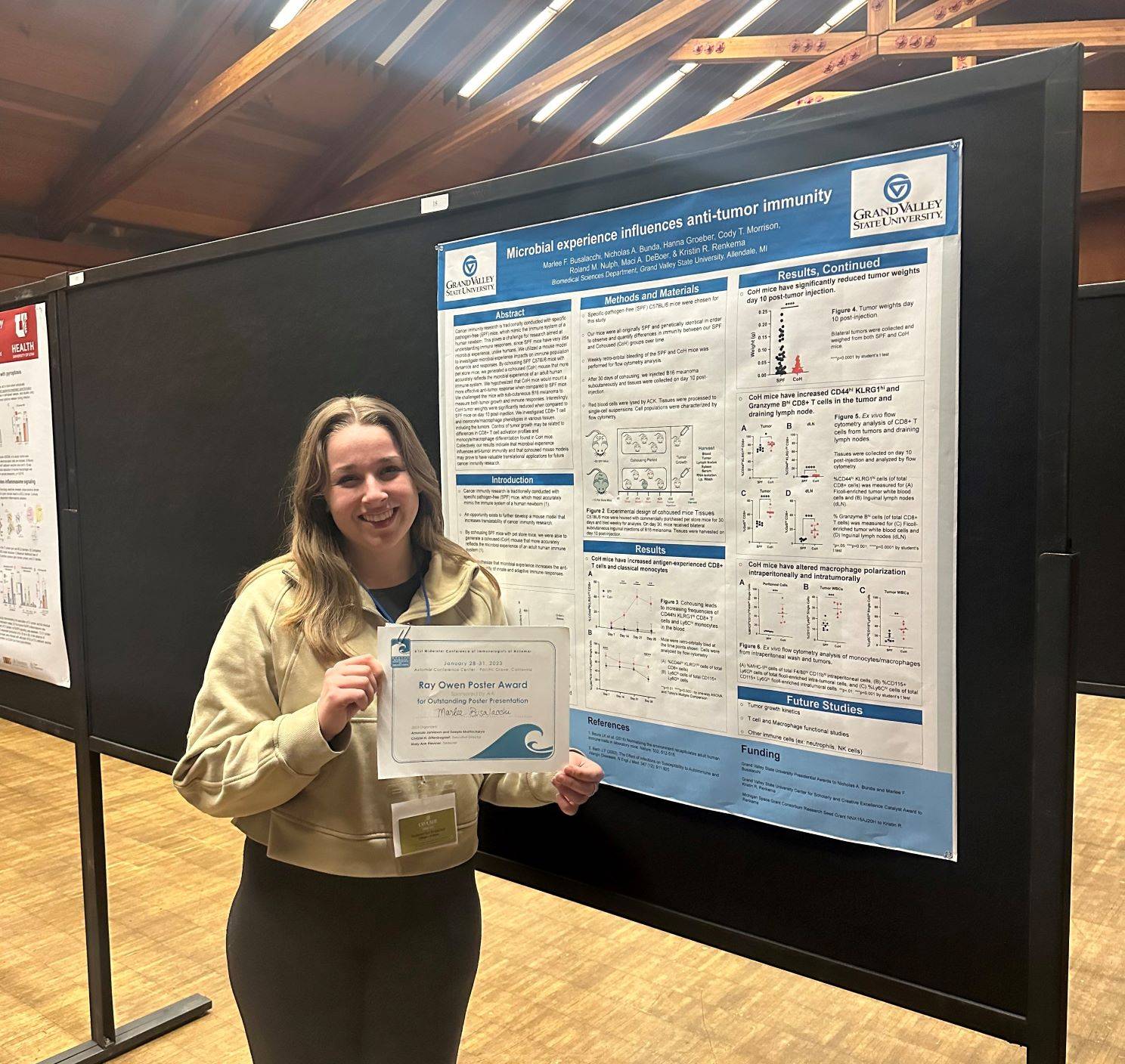 Marlee Busalacchi next to the award-winning poster at the 2023 Midwinter Conference of Immunologists
